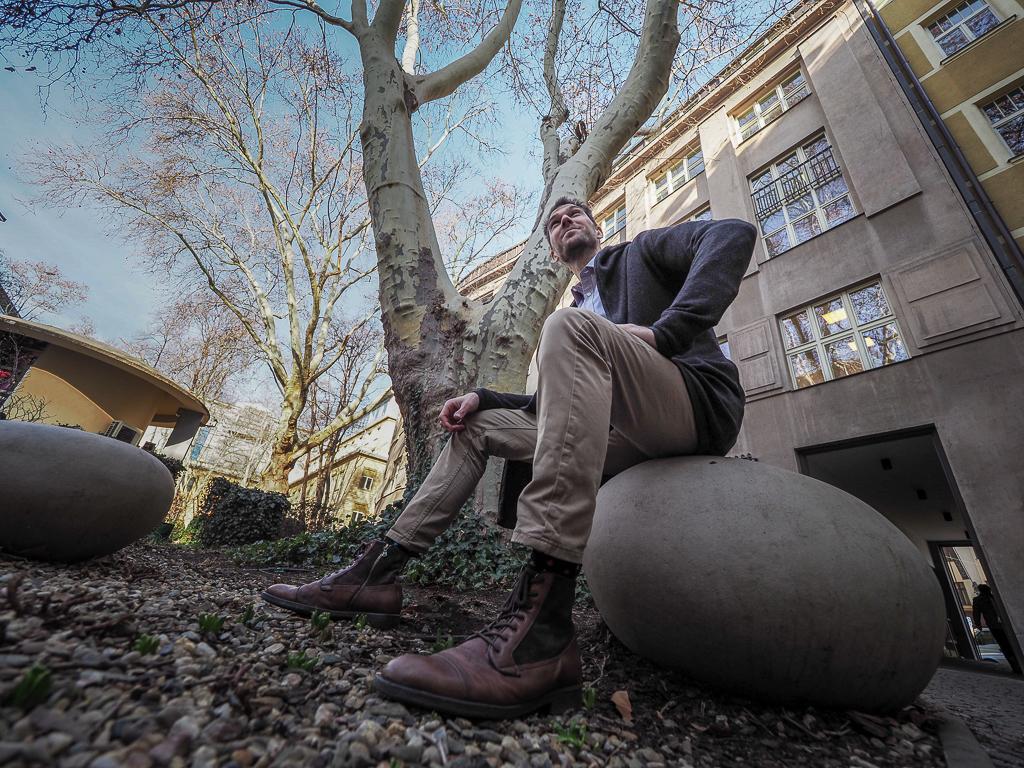 Jan Vojáček sedí v parku na kameni